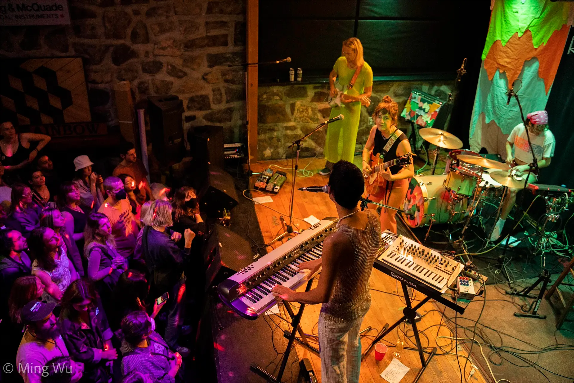 A band performs on stage while a lively crowd enjoys the music in front of them