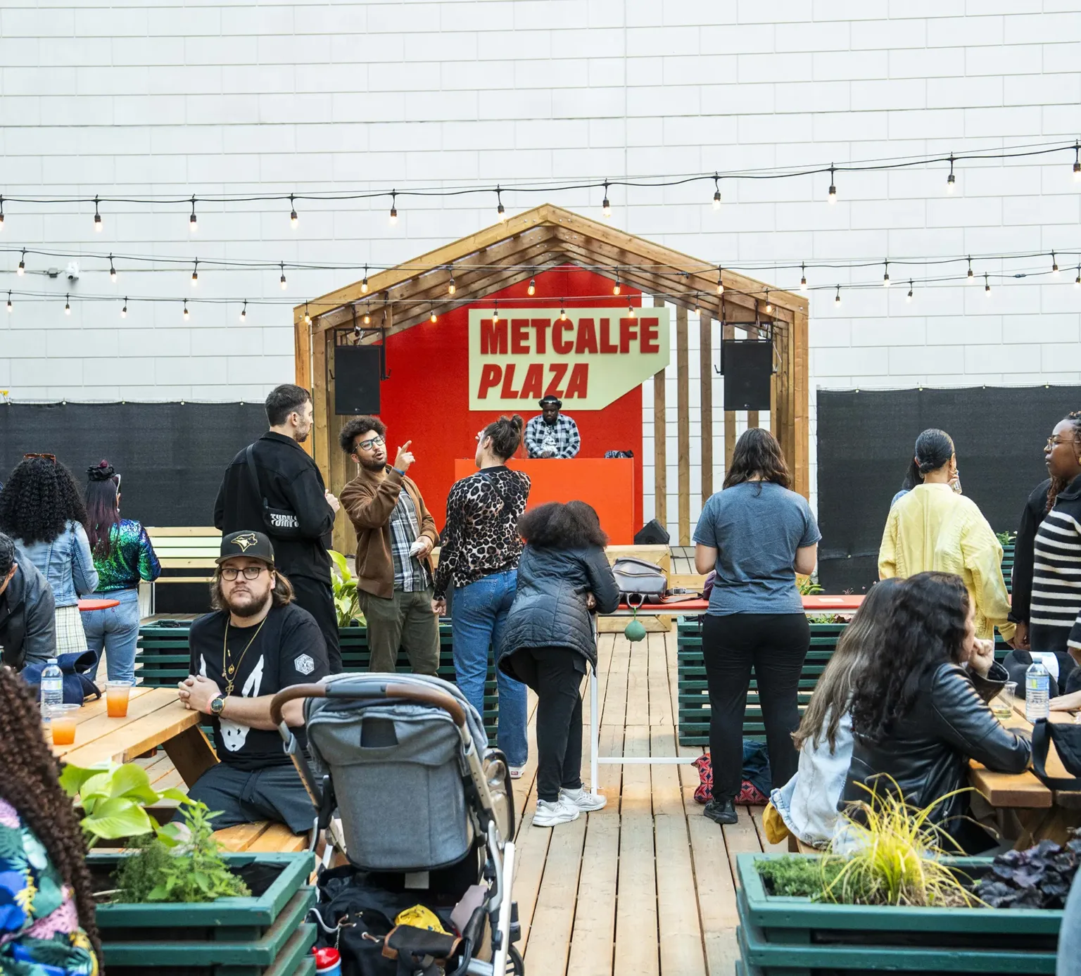 Groups of people sitting at tables in a vibrant courtyard