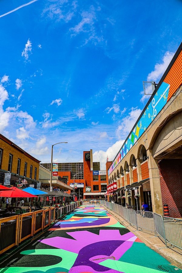 Colourful art covering road beside market patio